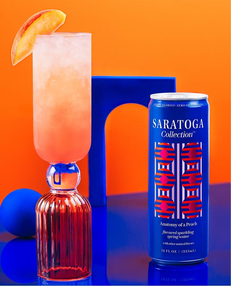 The Saratoga Collection Anatomy of a Peach cocktail with a can of Saratoga Collection Anatomy of a Peach.